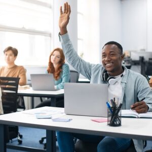 Portrait of black guy student raising hand at classroom